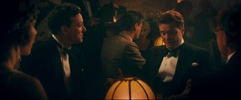 Movie still from “Magic in the Moonlight” (2014), directed by Woody Allen – A group of people sitting around a room; Medium shot, Over the shoulder angle