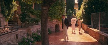Movie still from “Magic in the Moonlight” (2014), directed by Woody Allen – A man and a woman walking down a brick walkway; Wide shot, High angle