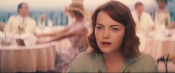 Movie still from “Magic in the Moonlight” (2014), directed by Woody Allen – Emma stone in a scene from woody allen's movie; Close Up shot, Over the shoulder angle