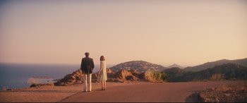Movie still from “Magic in the Moonlight” (2014), directed by Woody Allen – A man and a woman standing on the side of a road; Extreme Wide shot, High angle