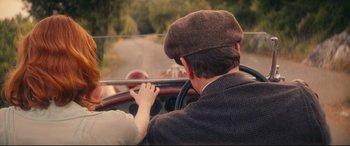 Movie still from “Magic in the Moonlight” (2014), directed by Woody Allen – A man driving a vintage car with a hat on; Medium shot, High angle