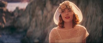 Movie still from “Magic in the Moonlight” (2014), directed by Woody Allen – A woman wearing a white hat with flowers on top of her head; Close Up shot, Over the shoulder angle