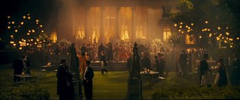 Movie still from “Magic in the Moonlight” (2014), directed by Woody Allen – A group of people standing in a field at night; Extreme Wide shot, High angle