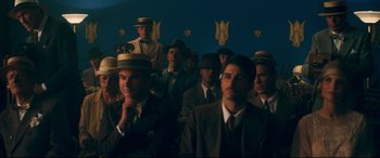 Movie still from “Magic in the Moonlight” (2014), directed by Woody Allen – A group of men in suits and hats in a room; Wide shot, Low angle