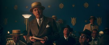 Movie still from “Magic in the Moonlight” (2014), directed by Woody Allen – A man in a suit and hat standing next to another man in a suit and hat; Medium shot, Low angle