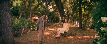 Movie still from “Magic in the Moonlight” (2014), directed by Woody Allen – A man and a woman sitting on a tree swing; Wide shot, High angle