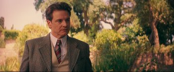 Movie still from “Magic in the Moonlight” (2014), directed by Woody Allen – A person wearing a suit and tie; Medium shot, Over the shoulder angle
