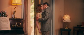 Movie still from “Magic in the Moonlight” (2014), directed by Woody Allen – A man and a woman kissing in front of an open door; Medium shot, Over the shoulder angle