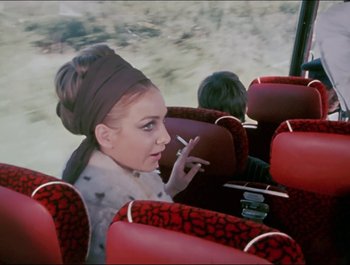 Movie still from “Magical Mystery Tour” (1967), directed by Ringo Starr – A woman smoking a cigarette while sitting on a bus; Medium shot, High angle