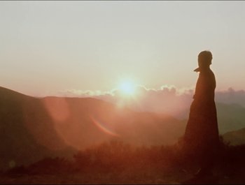 Movie still from “Magical Mystery Tour” (1967), directed by Ringo Starr – A person standing on top of a hill at sunset; Extreme Wide shot, Low angle