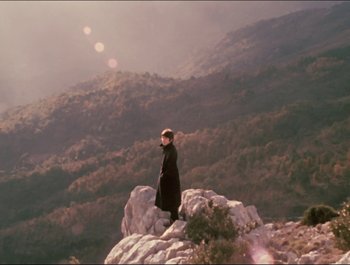 Movie still from “Magical Mystery Tour” (1967), directed by Ringo Starr – A man standing on top of a rock on top of a mountain; Extreme Wide shot, High angle