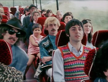 Movie still from “Magical Mystery Tour” (1967), directed by Ringo Starr – A group of people sitting on a bus; Medium shot, High angle