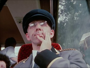 Movie still from “Magical Mystery Tour” (1967), directed by Ringo Starr – A man in a uniform sitting on a train; Close Up shot, Low angle