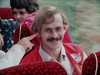 Movie still from “Magical Mystery Tour” (1967), directed by Ringo Starr – A man with a mustache and a red jacket; Close Up shot, Over the shoulder angle