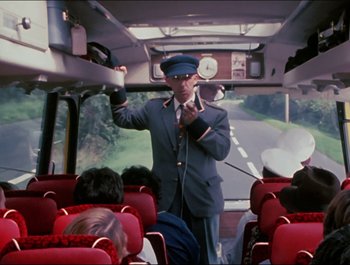 Movie still from “Magical Mystery Tour” (1967), directed by Ringo Starr – A man in a uniform is standing on a bus; Medium shot, High angle