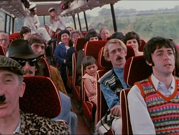 Movie still from “Magical Mystery Tour” (1967), directed by Ringo Starr – A group of people sitting on a bus; Wide shot, High angle