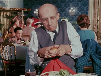 Movie still from “Magical Mystery Tour” (1967), directed by Ringo Starr – An older man sitting at a table eating a sandwich; Close Up shot, Over the shoulder angle