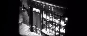 Movie still from “Magnolia” (1999), directed by Paul Thomas Anderson – An old chemist store with a lot of bottles on the shelves; Extreme Wide shot, High angle