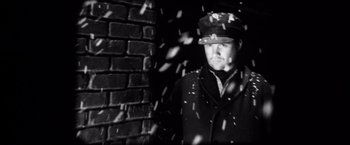 Movie still from “Magnolia” (1999), directed by Paul Thomas Anderson – A black and white photo of a man in a hat; Close Up shot, Low angle