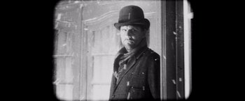 Movie still from “Magnolia” (1999), directed by Paul Thomas Anderson – A black and white photo of a man wearing a hat; Close Up shot, Low angle