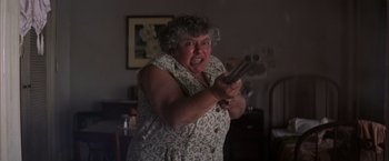 Movie still from “Magnolia” (1999), directed by Paul Thomas Anderson – An older woman is holding a gun in her hand; Close Up shot, Low angle