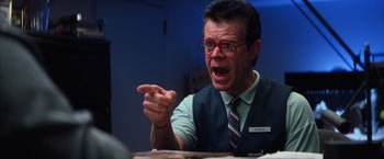 Movie still from “Magnolia” (1999), directed by Paul Thomas Anderson – A man in a vest and glasses is pointing at something; Close Up shot, Low angle