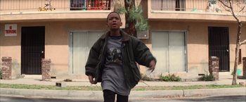 Movie still from “Magnolia” (1999), directed by Paul Thomas Anderson – A young boy is walking down the street; Medium shot, Low angle