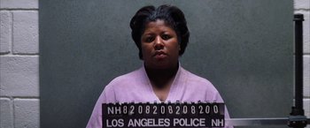 Movie still from “Magnolia” (1999), directed by Paul Thomas Anderson – A woman in a purple shirt is behind a police sign; Close Up shot, Low angle