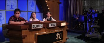 Movie still from “Magnolia” (1999), directed by Paul Thomas Anderson – Two young people sitting in front of a table; Medium shot, Low angle