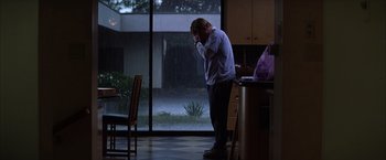 Movie still from “Magnolia” (1999), directed by Paul Thomas Anderson – A man standing next to a window in a room; Wide shot, Low angle