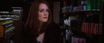 Movie still from “Magnolia” (1999), directed by Paul Thomas Anderson – A person sitting in front of a shelf; Close Up shot, Over the shoulder angle