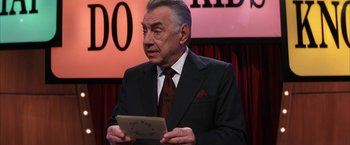 Movie still from “Magnolia” (1999), directed by Paul Thomas Anderson – An older man in a suit and tie holding a piece of paper in front of him; Close Up shot, Over the shoulder angle