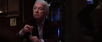 Movie still from “Magnolia” (1999), directed by Paul Thomas Anderson – An older man holding a wine glass while sitting at a table; Close Up shot, Low angle