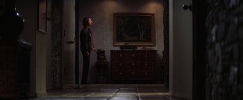 Movie still from “Magnolia” (1999), directed by Paul Thomas Anderson – A man standing in front of an antique dresser; Wide shot, Low angle