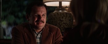 Movie still from “Magnolia” (1999), directed by Paul Thomas Anderson – A man sitting in front of a woman in front of a lamp; Close Up shot, Over the shoulder angle