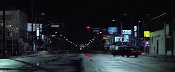 Movie still from “Magnolia” (1999), directed by Paul Thomas Anderson – A city street at night lit by street lights; Extreme Wide shot, High angle