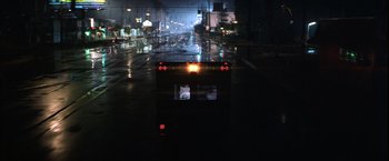 Movie still from “Magnolia” (1999), directed by Paul Thomas Anderson – A bus driving down a wet street at night; Extreme Wide shot, Low angle