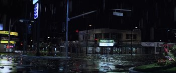 Movie still from “Magnolia” (1999), directed by Paul Thomas Anderson – A street sign on a pole in the middle of the night; Extreme Wide shot, High angle