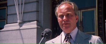 Movie still from “Magnum Force” (1973), directed by Ted Post – A person holding a microphone; Close Up shot, Low angle