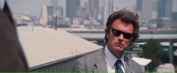 Movie still from “Magnum Force” (1973), directed by Ted Post – A person wearing a suit and sunglasses; Close Up shot, Low angle