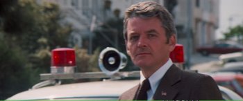 Movie still from “Magnum Force” (1973), directed by Ted Post – A person wearing a suit and tie; Close Up shot, Low angle
