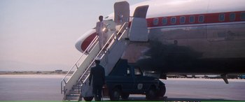 Movie still from “Magnum Force” (1973), directed by Ted Post – A man standing on the stairs of an airplane; Wide shot, High angle