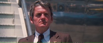 Movie still from “Magnum Force” (1973), directed by Ted Post – An older man in a suit and tie looking to his left; Close Up shot, Low angle