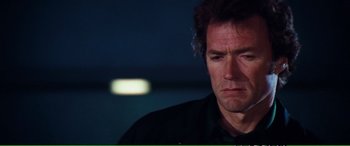 Movie still from “Magnum Force” (1973), directed by Ted Post – A person wearing a black shirt; Close Up shot, Over the shoulder angle