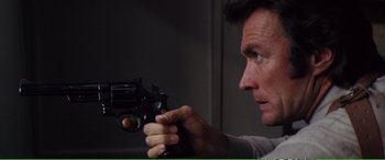 Movie still from “Magnum Force” (1973), directed by Ted Post – A person holding a gun; Close Up shot, High angle