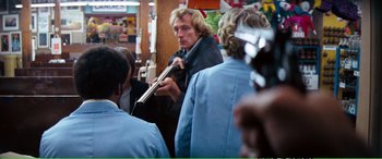 Movie still from “Magnum Force” (1973), directed by Ted Post – A group of people standing in a room; Medium shot, Over the shoulder angle