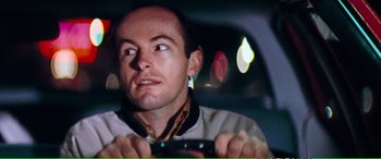 Movie still from “Magnum Force” (1973), directed by Ted Post – A man is driving in a car at night; Close Up shot, Over the shoulder angle