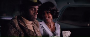 Movie still from “Magnum Force” (1973), directed by Ted Post – A man and a woman smiling for the camera; Close Up shot, Over the shoulder angle