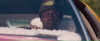 Movie still from “Magnum Force” (1973), directed by Ted Post – A man in a hat sitting in the driver's seat of a car; Close Up shot, Over the shoulder angle