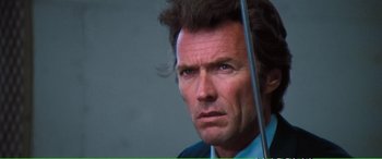 Movie still from “Magnum Force” (1973), directed by Ted Post – A person wearing a suit and tie; Close Up shot, Low angle